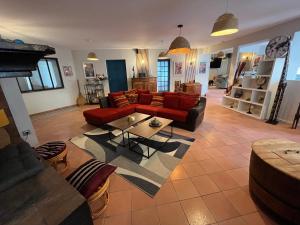 a living room with a red couch and a table at Magnifique et grand loft classé 4 étoiles in Lavelanet