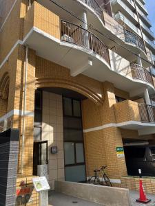 ein Gebäude, vor dem ein Fahrrad geparkt ist in der Unterkunft サンシティ大濠公園 in Susakiuramachi