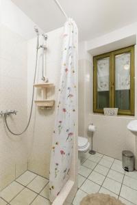 a bathroom with a shower curtain with a toilet at Dei Fiori Apartments in Rovinj +50 photos