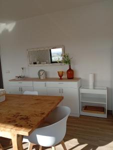 a kitchen with a wooden table and white cabinets at Casa da Marquinhas in Ventozelo