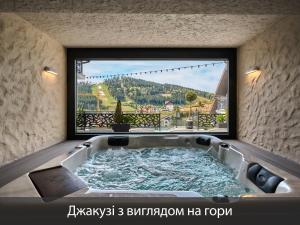 a bath tub in a room with a large window at Chalet Fomich in Bukovel