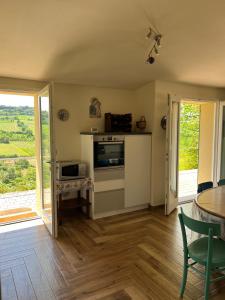 a living room with a kitchen and a table and chairs at La casina sulla valle in Dozza +11 photos