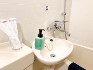 ein Badezimmer mit einem weißen Waschbecken und einer Toilette in der Unterkunft サンシティ大濠公園 in Susakiuramachi + 21 Fotos