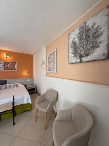 a bedroom with a bed and two chairs in it at Residenza Al Castello in Carloforte