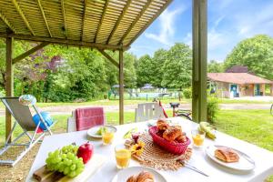 a table with a basket of bread and fruit at Camping Le Hameau du Petit Lay in Mouchamps