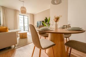 ein Esszimmer und ein Wohnzimmer mit Tisch und Stühlen in der Unterkunft Luma-Living Apartments in Dresden