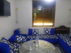 a living room with blue couches and a table at Appartement aissa in Oulad Akkou