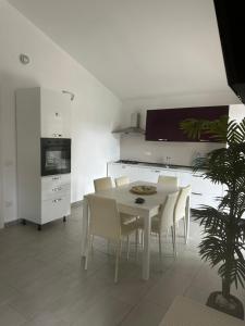 eine weiße Küche mit einem weißen Tisch und Stühlen in der Unterkunft Villa VAdel Zambrone Marina in Zambrone