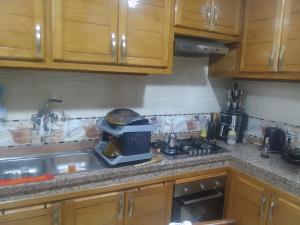 a kitchen counter with a microwave and a sink at Appartement aissa in Oulad Akkou