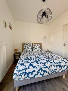 a bedroom with a bed with a blue and white comforter at Nid Urbain - 3 Ch et Terrasse in Saint-Herblain +5 photos