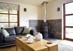 a living room with a leather couch and a stove at Canna Lodge in Duirinish