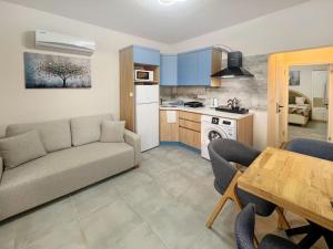 a living room with a couch and a table and a kitchen at Paddys Apartments Ovacık in Oludeniz