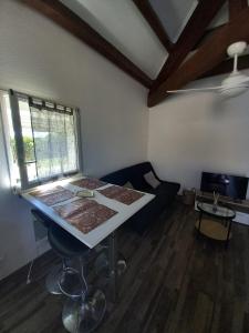 乐巴凯尔斯Superbe appartement terrasse piscine proche plage的客厅里有一张桌子和一张沙发 更多23张照片