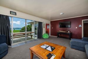 un soggiorno con un divano e un tavolo di Te Tiriti Beach House - Paihia Holiday Home a Paihia
