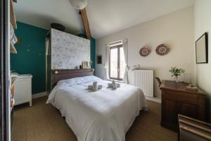 a bedroom with a large white bed and a window at La Rose du Petit Bois in Saint-Didier-au-Mont-dʼOr