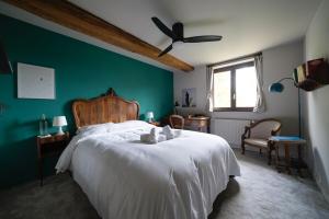 a bedroom with a white bed and a green wall at La Rose du Petit Bois in Saint-Didier-au-Mont-dʼOr