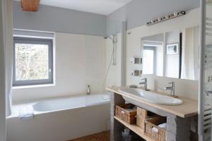 a white bathroom with a tub and a sink at La Rose du Petit Bois in Saint-Didier-au-Mont-dʼOr