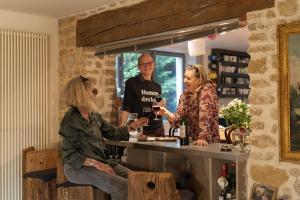 a group of people sitting at a counter drinking wine at La Rose du Petit Bois in Saint-Didier-au-Mont-dʼOr