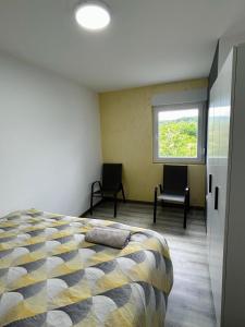 a bedroom with a bed and two chairs in it at Apartment Zlatna plaža in Bratunac