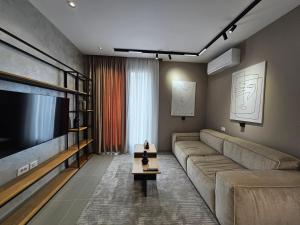 a living room with a couch and a large television at Valentino Noir in Tirana