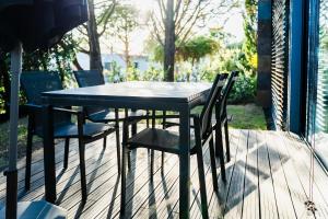 a black table and chairs on a deck at Designer Villa in Comporta in Troia