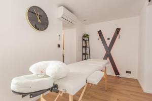 a white room with a clock on the wall at LoveRoom avec balnéo privative in Flémalle-Grande
