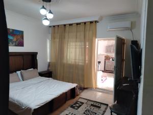 a bedroom with a bed and a tv and a window at شقه بغرفه وصاله وبلكونه بدون شراكة in Amman