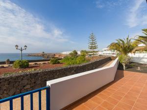 a walkway with a retaining wall next to the ocean at Las Moreras Playa Blanca in Playa Blanca