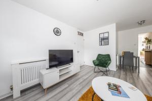 ルートンにあるExecutive One Bedroom Maisonette - Garden Access & Free Parking - Prime Locationの薄型テレビのある白いリビングルーム