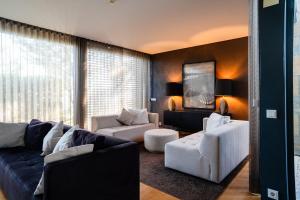 a living room with white furniture and a large window at Designer Villa in Comporta in Troia