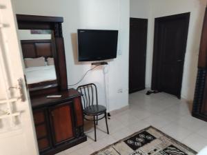 a room with a tv and a chair in a room at شقه بغرفه وصاله وبلكونه بدون شراكة in Amman