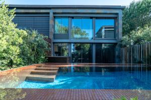 an external view of a house with a swimming pool at Designer Villa in Comporta in Troia