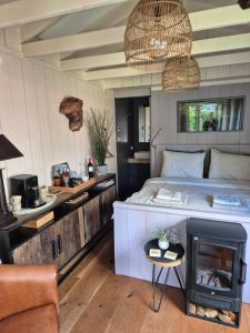 a bedroom with a bed and a fireplace at Tinyhouse met Hot Tub en ruime privé tuin in Gees