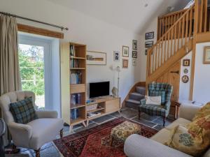 ein Wohnzimmer mit einer Treppe und einem TV in der Unterkunft Dragon Cottage in Axminster