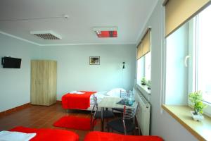 a room with a bed and a table and chairs at Hostel Bazar in Kraków