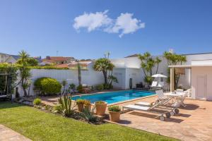 a backyard with a swimming pool and a house at Moradia exclusiva junto ao mar in Gafanha da Nazaré