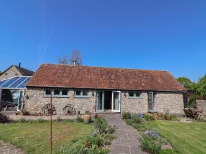 ein Steinhaus mit einem rostigen Dach in der Unterkunft Dragon Cottage in Axminster