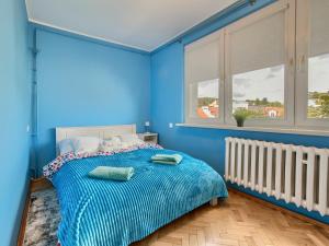 a blue bedroom with a bed with blue walls at Platinium Wrzeszcz - Batorego in Gdańsk