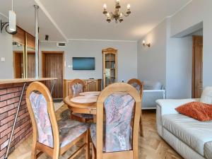 a dining room and living room with a table and chairs at Platinium Wrzeszcz - Batorego in Gdańsk