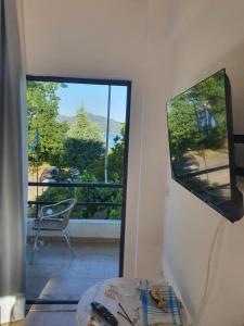 a living room with a view of a large window at Lou Apartments & Hostel in Edipsos