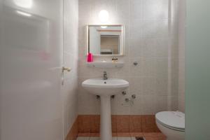 a bathroom with a sink and a toilet at Julia Hotel in Fourka