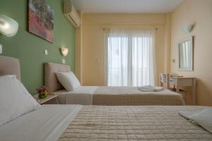 a hotel room with two beds and a window at Julia Hotel in Fourka