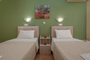 two beds sitting next to each other in a room at Julia Hotel in Fourka