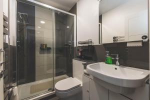 a bathroom with a toilet and a sink and a shower at Stylish Flat B in London +13 photos