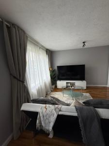 a living room with a couch and a tv at Rafiki Springs - Luxury 5-Bed Home in Milton Keynes in Milton Keynes