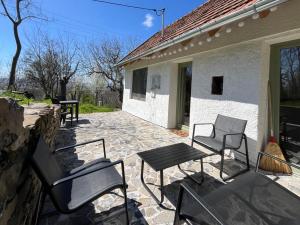 a patio with chairs and a table and a building at Bazalt Tigris Vendégház in Zalahaláp