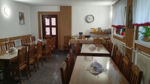 a dining room with tables and chairs and a clock at "Gawęckówka u Jasia i Małgosi" Krynica Zdrój in Krzyżówka