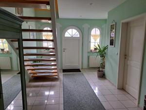 a hallway with green walls and a white door at Schönes Ferienhaus in Radewege mit schönem Garten in Radewege +14 photos