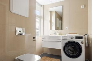 a bathroom with a washing machine and a sink at Sentral leilighet, Bergen in Bergen