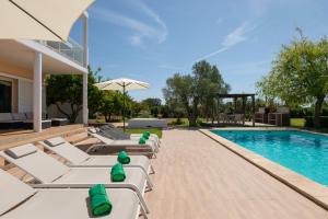 a pool with lounge chairs and a swimming pool at New! Villa Margarita - Ibiza in Santa Eularia des Riu +27 photos